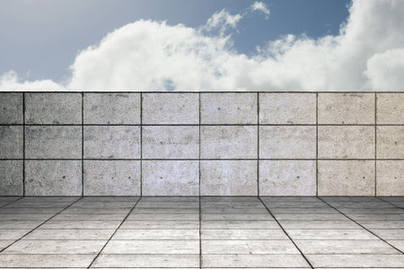 Low concrete tiled wall and matching floor are showing flat design plaza, with fluffy clouds. Urban, minimalist, modern, architectural, outdoor, leisure, geometricの写真素材