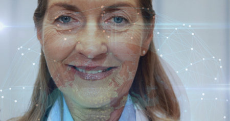 Displaying senior woman wearing white coat revealing glowing network overlay on face within office. Ethical, innovation, connectivity, intelligence, technology, healthcare, professionalの写真素材