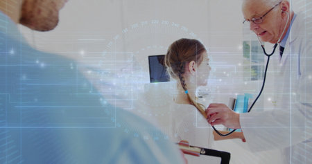 Listening physician using stethoscope on girl at exam table in clinic with clipboard and monitor....
