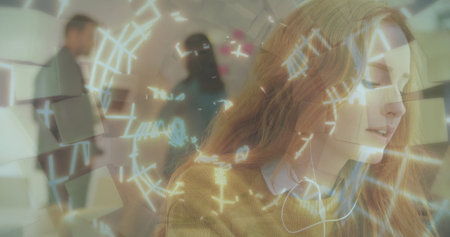 Woman wearing headphones and mustard sweater analyzing interface graphics in office, with panel....
