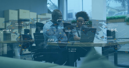 Collaborating colleagues analyzing data map overlay at office, with laptops notes pens and boxes. Corporate, teamwork, productivity, modern, digital, analytics, workspaceの写真素材