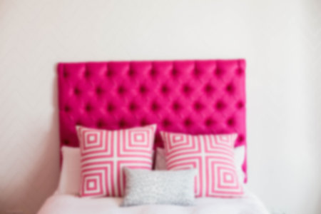 Pillows on bed against white wall at homeの写真素材