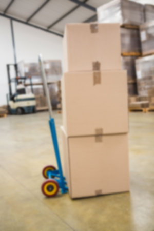 Close-up of cardboard boxes on fork lift in factory