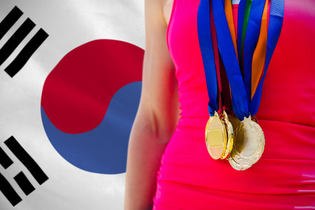 Midsection of female medalist standing against South Korean flagの写真素材