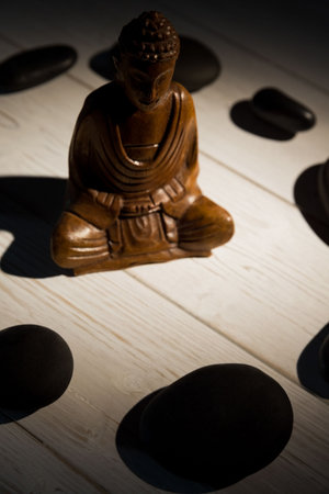 Close-up of Buddha figurine in circle made from pebblesの写真素材