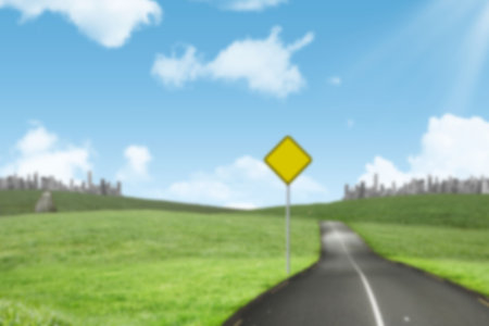 Yellow directional sign board on grass field against skyの写真素材