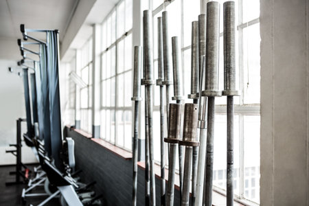 Barbells in exercise room by windowsの写真素材