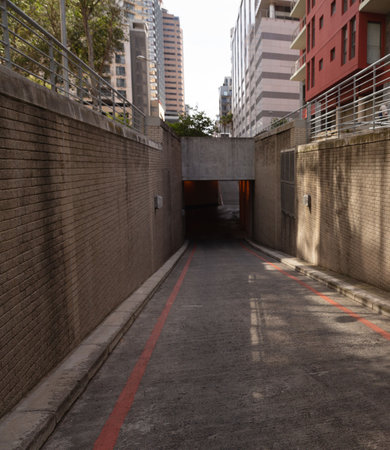 Flat design is showing descending concrete ramp between brick walls with railings and red lines. Urban, architecture, modern, textured, industrial, infrastructure, cityscapeの写真素材