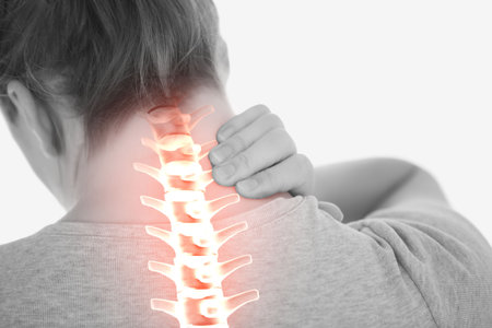 Digital composite of highlighted spine of woman with back painの写真素材