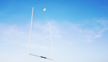 Rugby ball flying between postsの写真素材