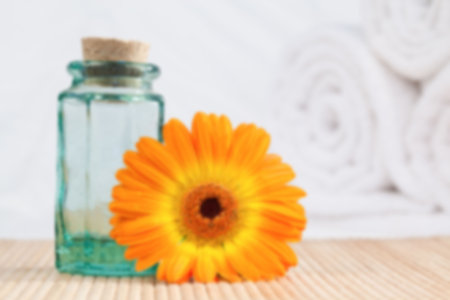 Oil with orange Gerbera daisy on table at spaの写真素材