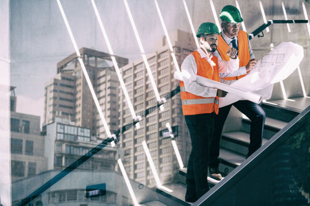 Digital composite image of male engineers discussing over blueprint in stairsの写真素材