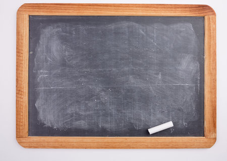 Chalkboard with piece of chalk on white background