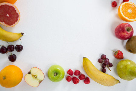 Overhead view of various fresh fruits on white background