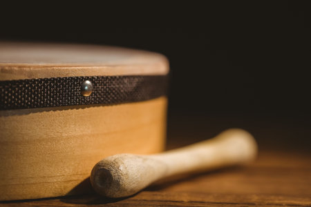 Close-up of wooden stick by bodhran on tableの写真素材