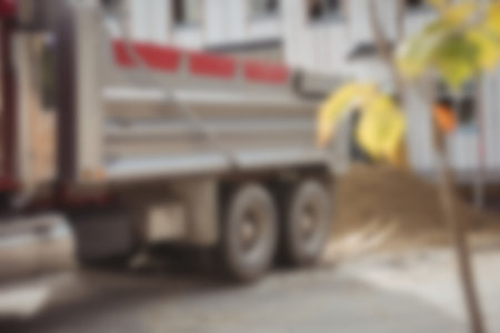 Defocused image of dumper truck unloading mud at construction siteの写真素材