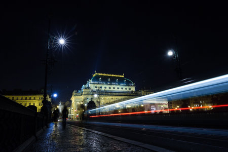 Displaying nighttime bridge in flat design featuring illuminated domed building, tram light trails. Urban, nightscape, architecture, motion, transportation, illumination, nostalgiaの写真素材
