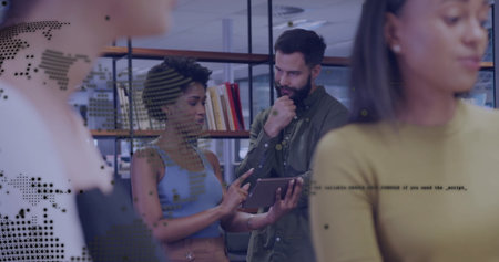 Discussing content colleague showing tablet while peer examining data in office with bookshelves. Collaboration, teamwork, professional, workspace, modern, education, communicationの写真素材