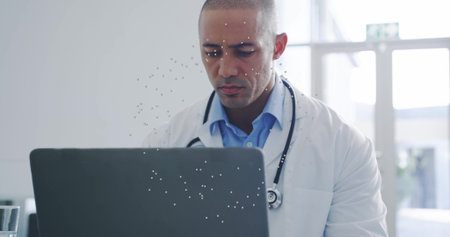 Typing on laptop, Hispanic doctor reviewing records at reception with stethoscope, glass of water....