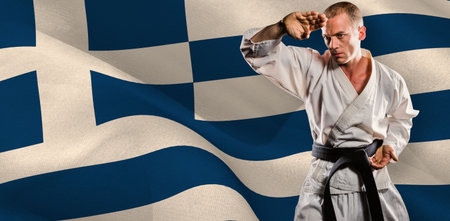 Male martial artist practicing karate against Greek flagの写真素材