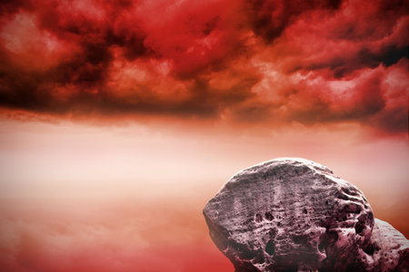 Digitally generated large rock overlooking red skyの写真素材