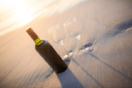 High angle view of wineglass and wine bottle on beachの写真素材