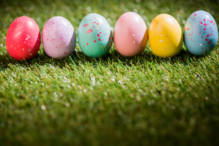 Row of colorful Easter eggs on grass in yard