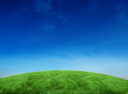 Grassy hill against blue sky