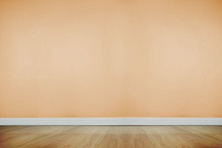 Blank peach-colored wall is being featured in flat design empty room with light wood floor....