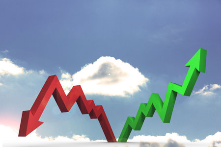 Red and green arrows pointing against skyの写真素材