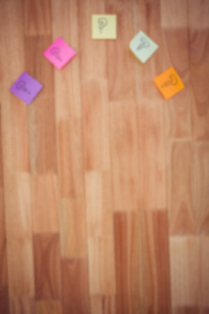 Overhead view of sticky notes with question marks on hardwood floorの写真素材