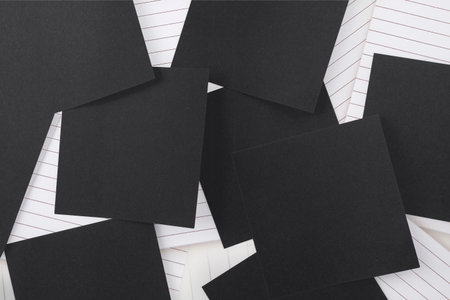 Black paper strewn over notepad paperの写真素材