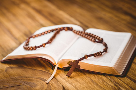 Close-up of rosary beads on open bibleの写真素材