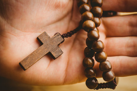 Close-up of hand holding rosary beads