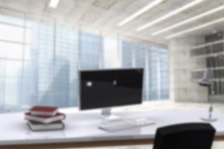 Defocused image of computer monitor on desk in officeの写真素材