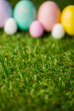 Colorful Easter eggs with focus on grass in garden