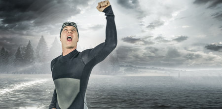 Composite image of excited male swimmer with arm raised against sea