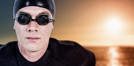 Close up portrait of male swimmer on shore against sky during sunsetの写真素材