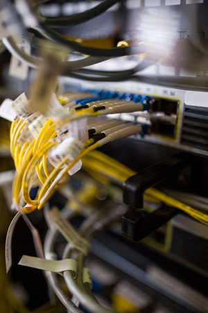 Fiber optic patch panel with yellow cables is being shown in flat design inside server rack....