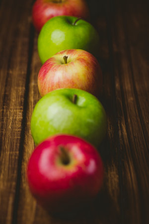 Red and green apples on wooden tableの写真素材