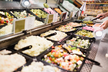 Cropped image of hands serving food at supermarketの写真素材