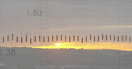 Glowing sun disk peeking through layered clouds above hillside at sunset, with measurement overlay....