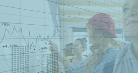 Analyzing team reviewing financial data on glass board in office with dry-erase markers, line graph....