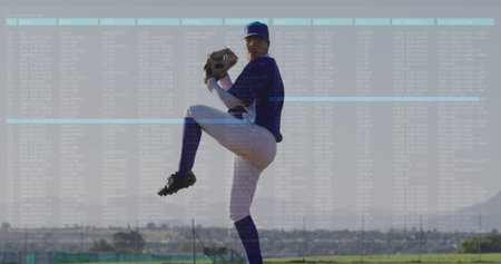 Pitching pitcher wearing jersey holding glove and ball on pitchers mound, with fence and bleachers. Athlete, sports, outdoor, dynamic, competitive, action, stadiumの写真素材
