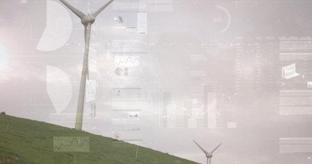 Monitoring white wind turbine rotating on grassy hillside at wind farm, with digital data overlays. Sustainable, renewable, technology, ecofriendly, innovation, analytics, environmentalの写真素材