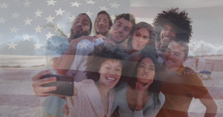 Smiling group of friends taking selfie at sandy beach, with smartphone and American flag overlay....