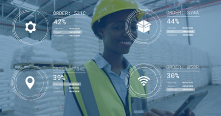 Monitoring woman in safety vest hard-hat using tablet in warehouse by stacks, with virtual overlays....