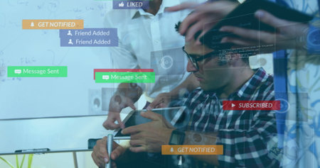 Collaborating tech team reviewing designs in meeting room, with tablet smartphone whiteboard marker....