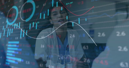Doctor in scrubs reviewing digital charts on panel at hospital meeting, with laptop and stethoscope. Medical, collaboration, technology, healthcare, analytics, professionalism, data visualizationの写真素材