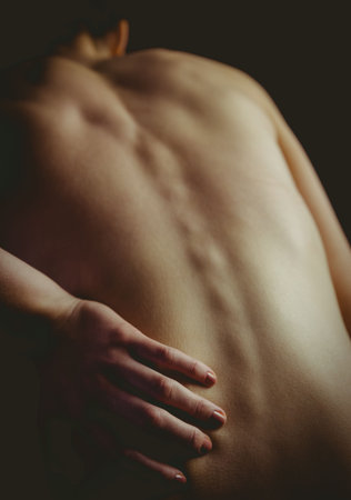 Woman's bare back and spine is being accentuated in 3D render by soft highlights and shadows. Human anatomy, wellness, artistic photography, minimalism, health, beauty, textureの写真素材